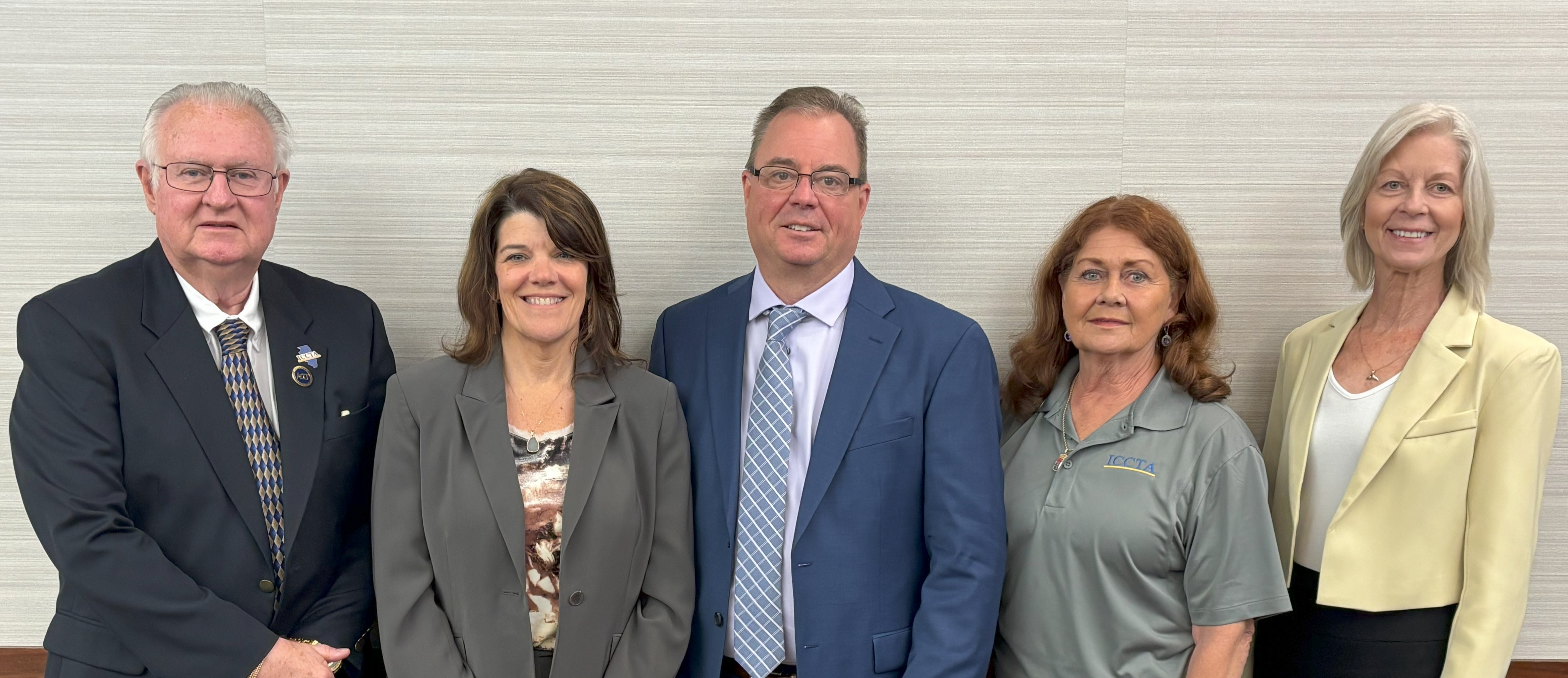 Image of five members of ICCTA leadership team standing against a off-white background and smiling