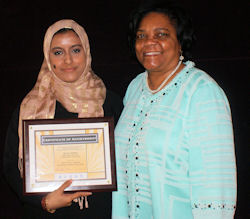 Moraine Valley Community College student Nada Omer (left) accepts her $500 Paul Simon Student Essay Contest scholarship from MVCC president Dr. Sylvia Jenkins.